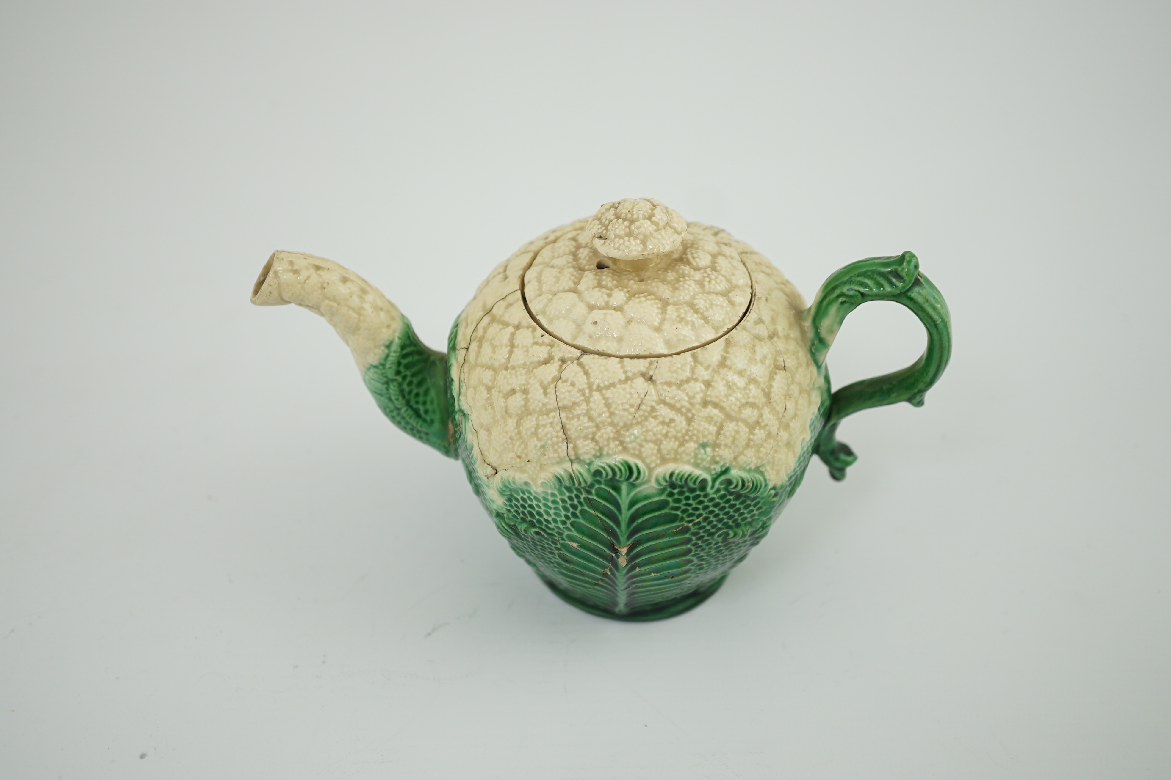 A Staffordshire cauliflower shaped creamware teapot and cover, c.1770, 10. 5 cm high. Condition - broken and repaired